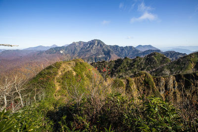 Scenic view of mountains against blue sky