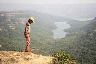 Side view of boy standing on mountain