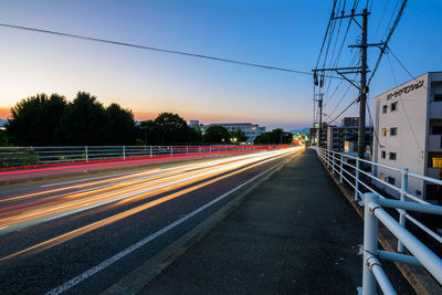 Light trails on road against sky during sunset