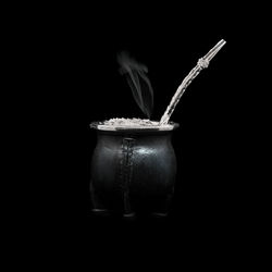 Close-up of jar on table against black background