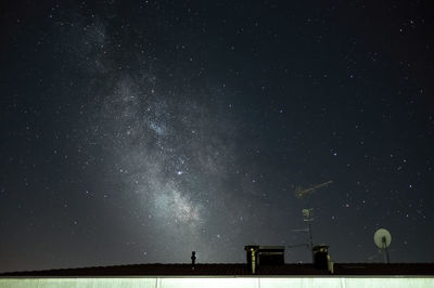 Low angle view of satellite dishes on roof against sky at night