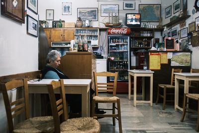 Man sitting on chair at table against building