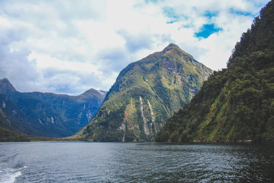 Scenic view of lake by mountains against sky