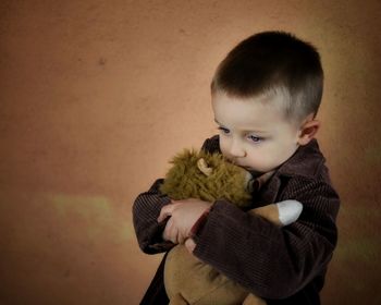 Portrait of cute boy holding toy