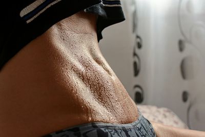 Midsection of woman with sweaty abdomen