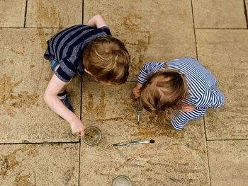 High angle view of siblings playing on floor