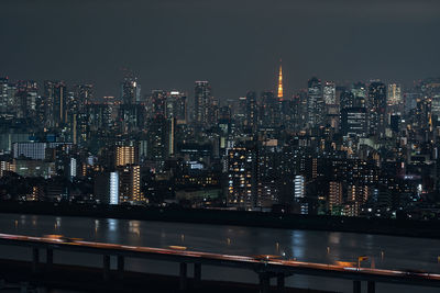Illuminated buildings in city against sky at night