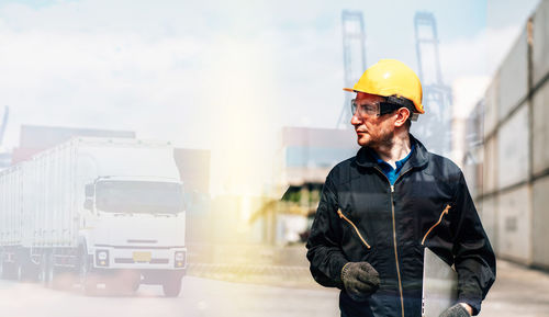 Man working with arms raised standing in background