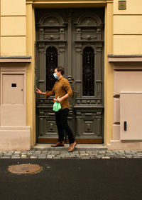 Side view of woman standing against building