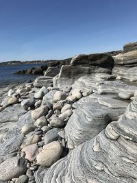 Rocks on beach against clear sky