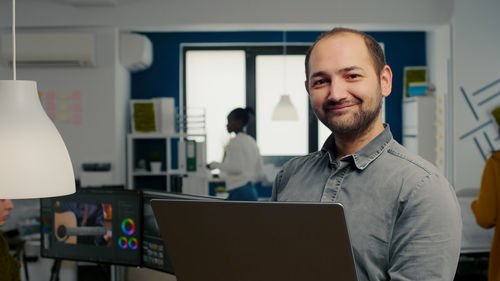 Portrait of smiling man using laptop