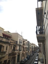 Cars on road against sky in city