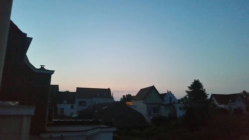 Buildings against clear sky at sunset