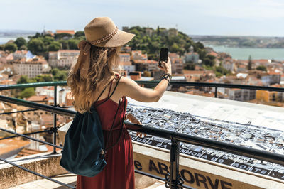 Woman standing on railing in city