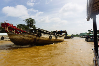 Boat moored on beach against sky