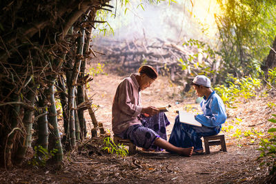 Rear view of a man sitting in forest