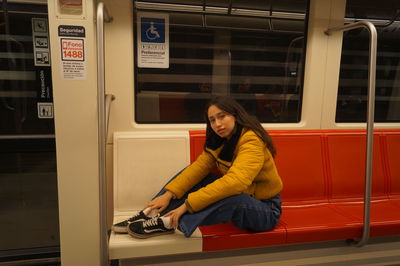 Portrait of young woman sitting on mobile phone