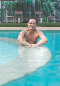 Portrait of smiling man swimming in pool