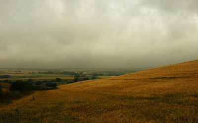 Scenic view of field against cloudy sky