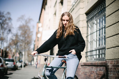Young woman riding bicycle in city