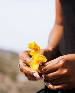 Close-up of woman holding flowers against blurred background