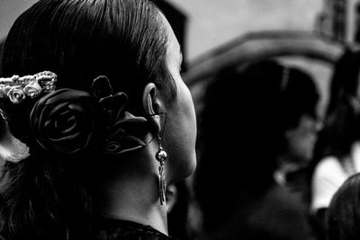 Side view of young woman wearing earring and hair accessory outdoors