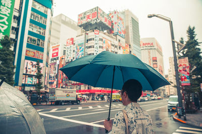 Rear view of man on wet street in city
