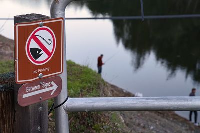 Close-up of road sign by railing