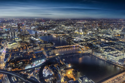 High angle view of illuminated city by river at night