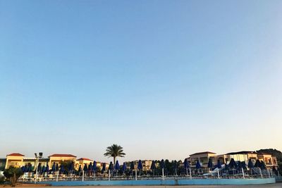 View of swimming pool by sea against clear blue sky