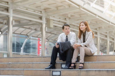 Young couple sitting outdoors