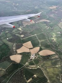 Aerial view of airplane flying over agricultural field