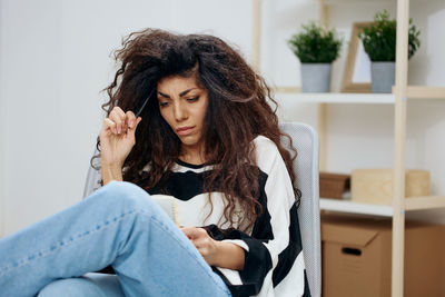 Woman with messy hair sitting on chair