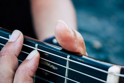 Close-up of hands playing guitar