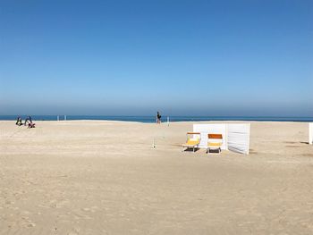 Scenic view of beach against clear blue sky