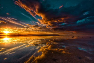 Scenic view of sea against dramatic sky during sunset