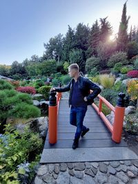 Full length of man standing on footpath by trees