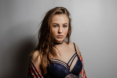 Portrait of young woman against gray background