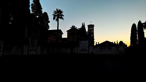 Silhouette buildings against sky at dusk