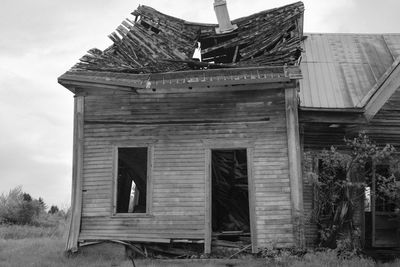 Low angle view of old abandoned house against sky