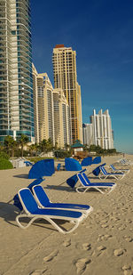 View of modern buildings at beach against blue sky