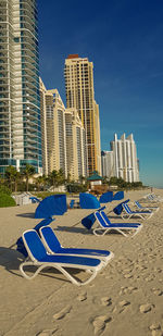 View of modern buildings at beach against blue sky
