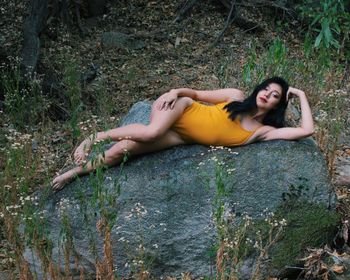 High angle portrait of woman lying on rock