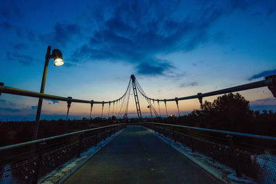 Illuminated suspension bridge against sky at night