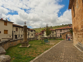 Street amidst buildings in town against sky