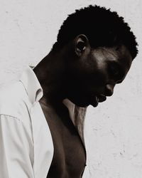 Close-up of young man looking away against wall