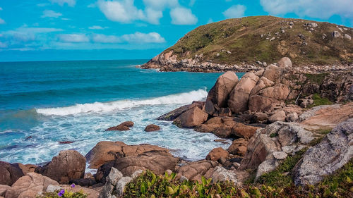 Rock formation on beach against sky