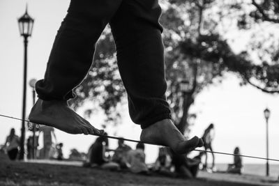 Low section of person slacklining against tree