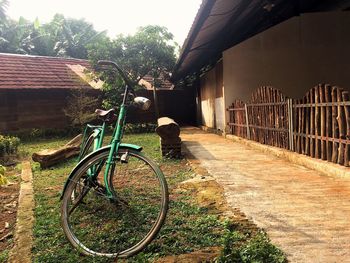 Bicycle by house against sky