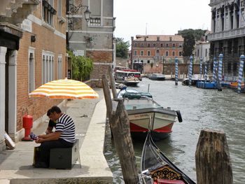 Man sitting on boat in city